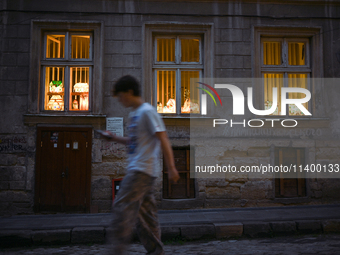 Lamps made of stained glass are on display in the windows of architect Pavlovsky's studio during a power outage at night in Lviv, Ukraine, o...