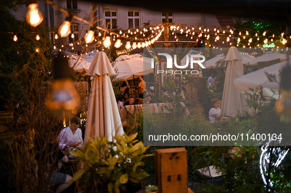 People are staying at an outdoor cafe in a courtyard in Lviv, Ukraine, on July 5, 2024. NO USE RUSSIA. NO USE BELARUS. 