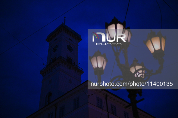 A lamppost is shining near the Lviv Town Hall at night in Lviv, Ukraine, on July 5, 2024. NO USE RUSSIA. NO USE BELARUS. 