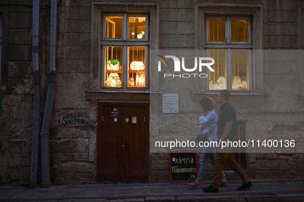 Lamps made of stained glass are on display in the windows of architect Pavlovsky's studio during a power outage at night in Lviv, Ukraine, o...