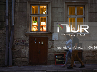 Lamps made of stained glass are on display in the windows of architect Pavlovsky's studio during a power outage at night in Lviv, Ukraine, o...