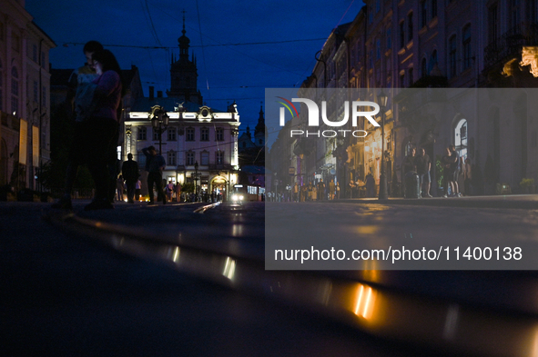 People are seeing in Rynok Square during a power outage at night in Lviv, Ukraine, on July 5, 2024. NO USE RUSSIA. NO USE BELARUS. 