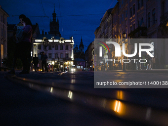 People are seeing in Rynok Square during a power outage at night in Lviv, Ukraine, on July 5, 2024. NO USE RUSSIA. NO USE BELARUS. (