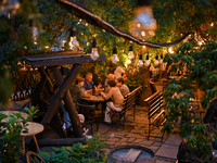 People are staying at an outdoor cafe in a courtyard in Lviv, Ukraine, on July 5, 2024. NO USE RUSSIA. NO USE BELARUS. (