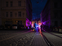 Pedestrians are crossing tram tracks in Katedralna Square at night in Lviv, Ukraine, on July 5, 2024. NO USE RUSSIA. NO USE BELARUS. (