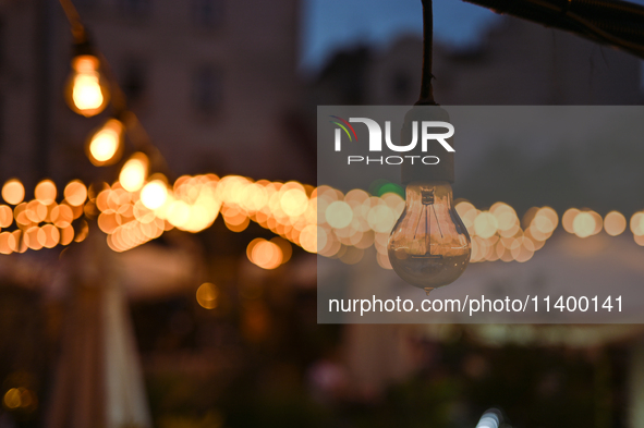 A light bulb is hanging in one of the outdoor cafes in Lviv, Ukraine, on July 5, 2024. NO USE RUSSIA. NO USE BELARUS. 