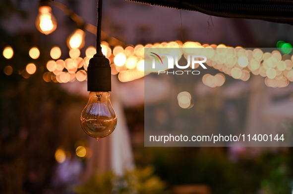 A light bulb is hanging in one of the outdoor cafes in Lviv, Ukraine, on July 5, 2024. NO USE RUSSIA. NO USE BELARUS. 