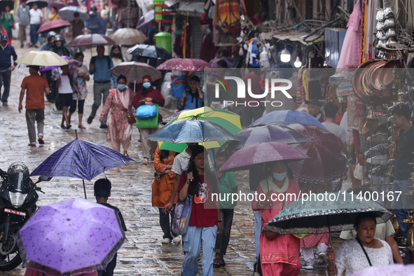 People are taking shelter from the rain in Kathmandu, Nepal, on July 11, 2024, after the reactivation of the monsoon climatic effect in the...