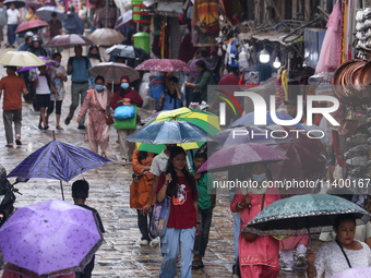 People are taking shelter from the rain in Kathmandu, Nepal, on July 11, 2024, after the reactivation of the monsoon climatic effect in the...