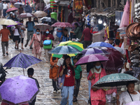 People are taking shelter from the rain in Kathmandu, Nepal, on July 11, 2024, after the reactivation of the monsoon climatic effect in the...