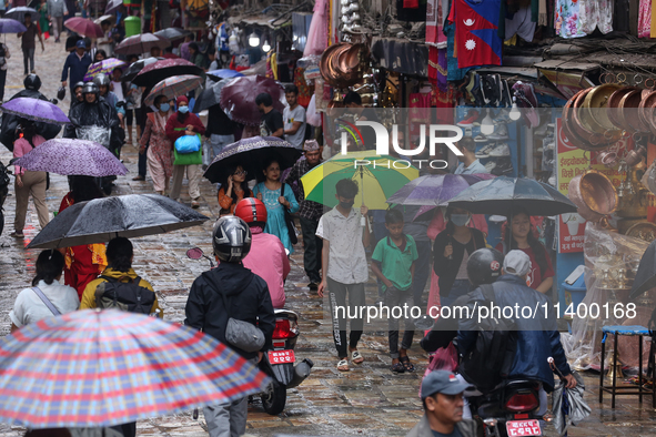 People are taking shelter from the rain in Kathmandu, Nepal, on July 11, 2024, after the reactivation of the monsoon climatic effect in the...