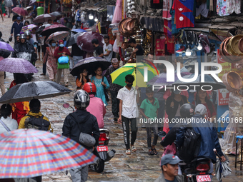 People are taking shelter from the rain in Kathmandu, Nepal, on July 11, 2024, after the reactivation of the monsoon climatic effect in the...