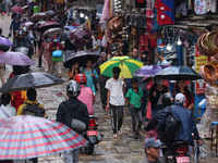 People are taking shelter from the rain in Kathmandu, Nepal, on July 11, 2024, after the reactivation of the monsoon climatic effect in the...