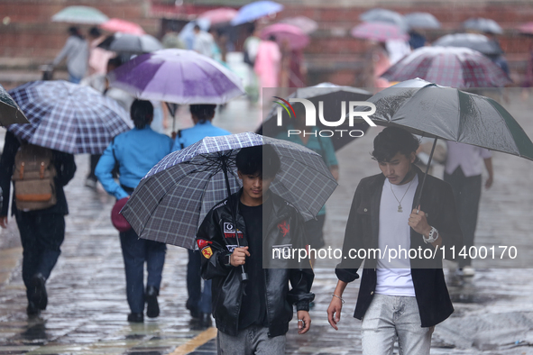 People are taking shelter from the rain in Kathmandu, Nepal, on July 11, 2024, after the reactivation of the monsoon climatic effect in the...