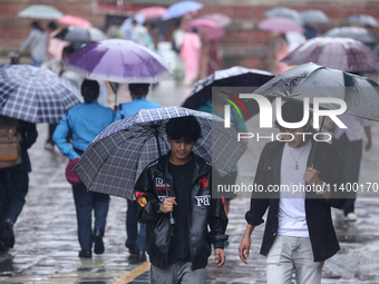 People are taking shelter from the rain in Kathmandu, Nepal, on July 11, 2024, after the reactivation of the monsoon climatic effect in the...