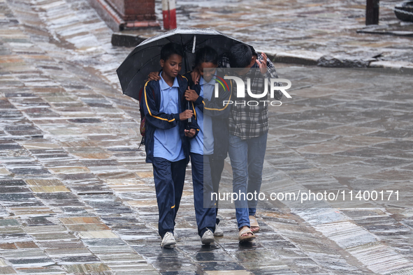 People are taking shelter from the rain in Kathmandu, Nepal, on July 11, 2024, after the reactivation of the monsoon climatic effect in the...