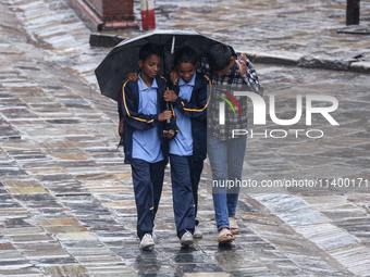 People are taking shelter from the rain in Kathmandu, Nepal, on July 11, 2024, after the reactivation of the monsoon climatic effect in the...