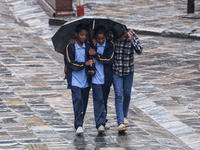 People are taking shelter from the rain in Kathmandu, Nepal, on July 11, 2024, after the reactivation of the monsoon climatic effect in the...