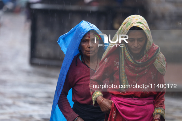 People are taking shelter from the rain in Kathmandu, Nepal, on July 11, 2024, after the reactivation of the monsoon climatic effect in the...