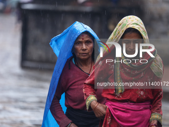 People are taking shelter from the rain in Kathmandu, Nepal, on July 11, 2024, after the reactivation of the monsoon climatic effect in the...