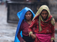 People are taking shelter from the rain in Kathmandu, Nepal, on July 11, 2024, after the reactivation of the monsoon climatic effect in the...