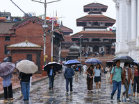 People are taking shelter under umbrellas as they walk in the rain in Kathmandu, Nepal, on July 11, 2024. Nepal is recording heavy rainfall...