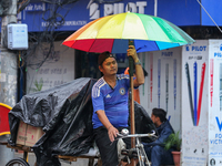 A daily wage worker is covering himself and his loads with sacks and plastic as he walks through the rain in Kathmandu, Nepal, on July 11, 2...