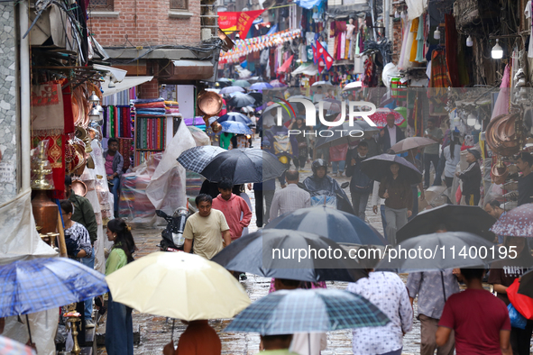 A marketway in Kathmandu, Nepal, on July 11, 2024, is filling with umbrellas as rain continues to pour. Nepal is recording heavy rainfall si...