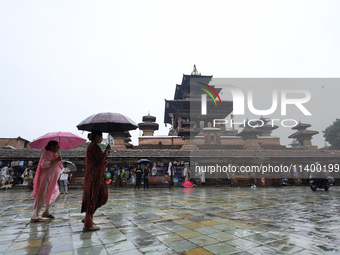 People are taking shelter under umbrellas as they walk in the rain in Kathmandu, Nepal, on July 11, 2024. Nepal is recording heavy rainfall...