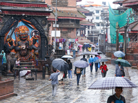 People are taking shelter under umbrellas as they walk in the rain in Kathmandu, Nepal, on July 11, 2024. Nepal is recording heavy rainfall...