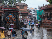 People are taking shelter under umbrellas as they walk in the rain in Kathmandu, Nepal, on July 11, 2024. Nepal is recording heavy rainfall...