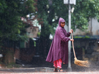 A sanitation worker is donning a raincoat and sweeping the courtyard of Basantapur Durbar Square, a UNESCO World Heritage Site, in Kathmandu...