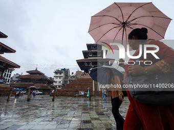 People are taking shelter under umbrellas as they walk in the rain in Kathmandu, Nepal, on July 11, 2024. Nepal is recording heavy rainfall...