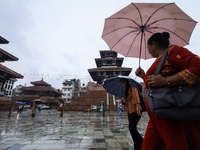 People are taking shelter under umbrellas as they walk in the rain in Kathmandu, Nepal, on July 11, 2024. Nepal is recording heavy rainfall...