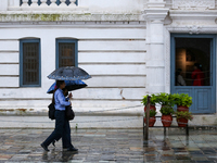 People are taking shelter under umbrellas as they walk in the rain in Kathmandu, Nepal, on July 11, 2024. Nepal is recording heavy rainfall...