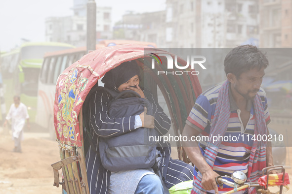 Residents are riding on rickshaws on a dusty road in Dhaka, Bangladesh, on July 11, 2024. 