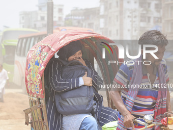 Residents are riding on rickshaws on a dusty road in Dhaka, Bangladesh, on July 11, 2024. (