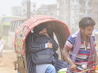 Residents are riding on rickshaws on a dusty road in Dhaka, Bangladesh, on July 11, 2024. (