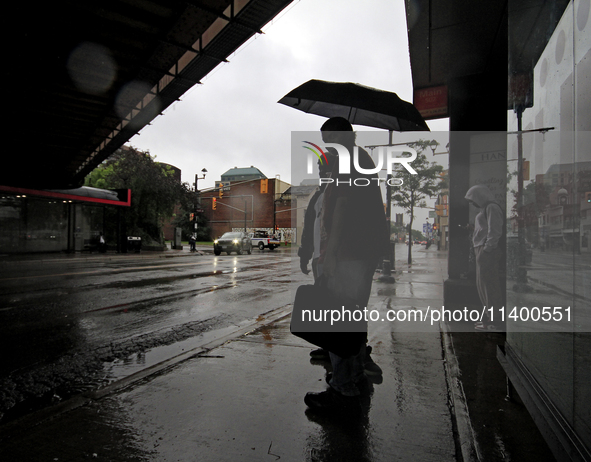 Pedestrians are waiting for public transportation on Main Street in Brampton, Ontario, on July 10, 2024. Remnants of Hurricane Beryl are pas...