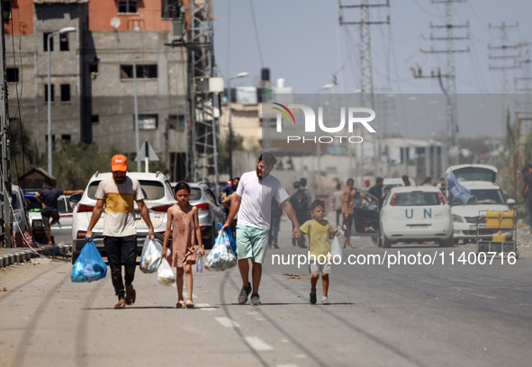 Displaced Palestinians, who are fleeing north Gaza after being ordered by the Israeli army to move southward amid the Israel-Hamas conflict,...