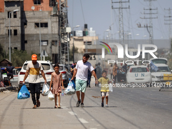 Displaced Palestinians, who are fleeing north Gaza after being ordered by the Israeli army to move southward amid the Israel-Hamas conflict,...