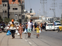 Displaced Palestinians, who are fleeing north Gaza after being ordered by the Israeli army to move southward amid the Israel-Hamas conflict,...