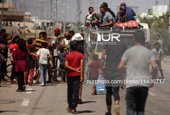 Displaced Palestinians, who are fleeing north Gaza after being ordered by the Israeli army to move southward amid the Israel-Hamas conflict,...