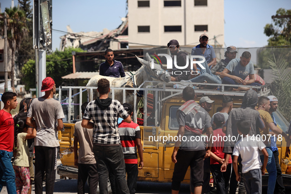 Displaced Palestinians, who are fleeing north Gaza after being ordered by the Israeli army to move southward amid the Israel-Hamas conflict,...