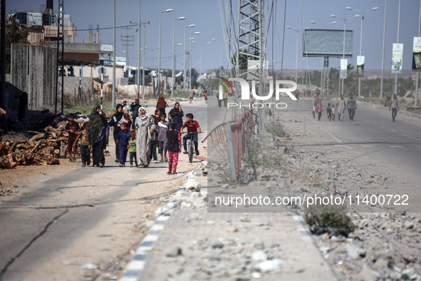 Displaced Palestinians, who are fleeing north Gaza after being ordered by the Israeli army to move southward amid the Israel-Hamas conflict,...