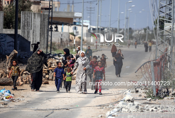 Displaced Palestinians, who are fleeing north Gaza after being ordered by the Israeli army to move southward amid the Israel-Hamas conflict,...