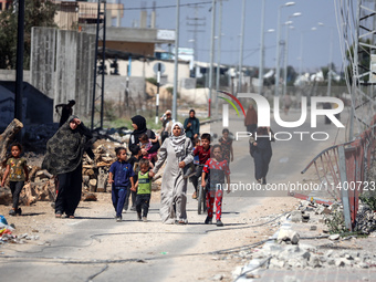 Displaced Palestinians, who are fleeing north Gaza after being ordered by the Israeli army to move southward amid the Israel-Hamas conflict,...