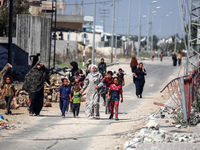 Displaced Palestinians, who are fleeing north Gaza after being ordered by the Israeli army to move southward amid the Israel-Hamas conflict,...