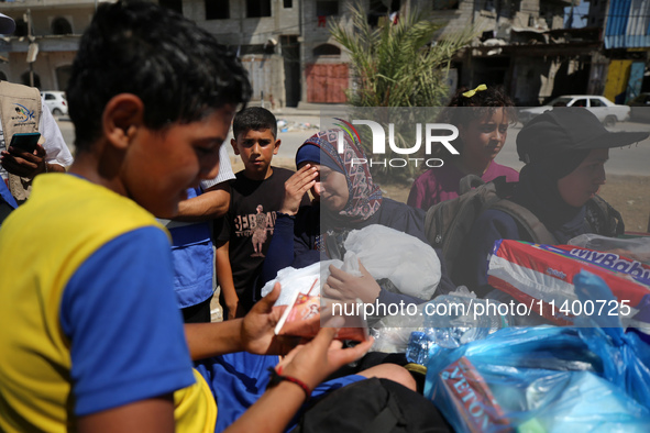 Displaced Palestinians, who are fleeing north Gaza after being ordered by the Israeli army to move southward amid the Israel-Hamas conflict,...