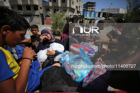 Displaced Palestinians, who are fleeing north Gaza after being ordered by the Israeli army to move southward amid the Israel-Hamas conflict,...